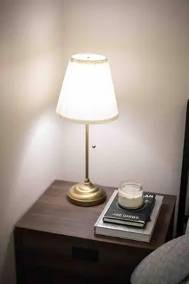 a lamp on a table with a clock on it at Cozy 1BR with Balcony and Netflix in Uptown BGC in Manila