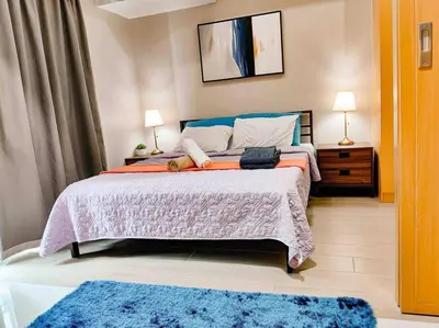 a bedroom with a large bed with two pillows at Cozy 1BR with Balcony and Netflix in Uptown BGC in Manila