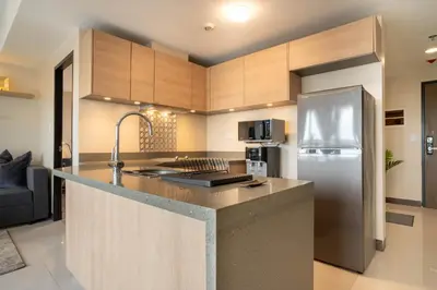 a kitchen with a stainless steel refrigerator and cabinets at Luxury Condo at Venice Mall near Airport, BGC & Makati in Manila