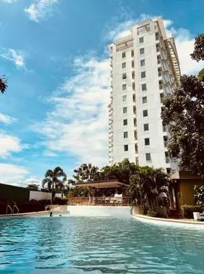 a swimming pool in front of a tall building at Anuva Stays in Manila