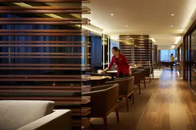 a woman standing in a library with a stack of books at Hyatt Regency Manila City of Dreams in Manila