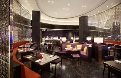 a restaurant with tables and chairs and a bar at Hyatt Regency Manila City of Dreams in Manila