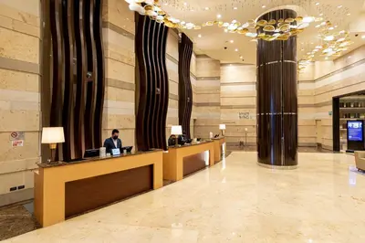 a lobby with a man sitting at a reception desk at Hyatt Regency Manila City of Dreams in Manila