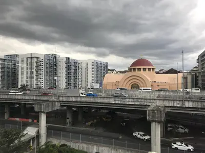 a bridge over a city with buildings and cars on it at Condo 1 Palm Tree Across NAIA T3 in Manila