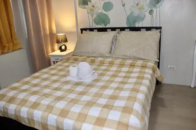 a bed with a hat and towels on it at Condo 1 Palm Tree Across NAIA T3 in Manila
