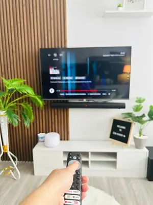 a person holding a remote control in front of a tv at Zen Haven Staycation beside EK in Santa Rosa