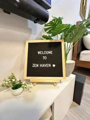 a chalkboard sign on a table with plants at Zen Haven Staycation beside EK in Santa Rosa