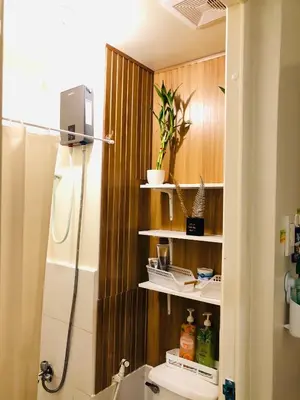 a bathroom with a shower and a toilet with shelves at Not active listing in Manila