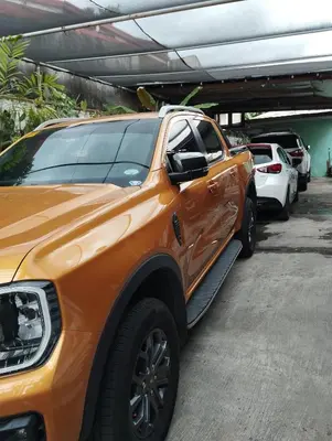 an orange truck parked in a parking lot at 15 Guest - Unit 1&2 House type and Studio type in Pasong Mannga