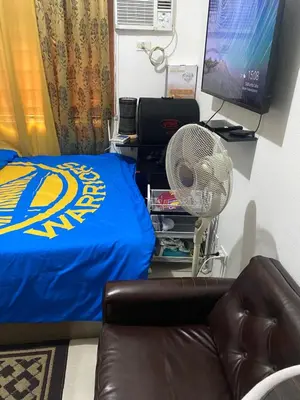 a bedroom with a bed and a fan and a television at Pierrecondotel in Manila