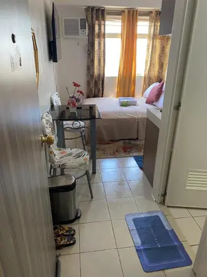 a small room with a bed and a table and a chair at Pierrecondotel in Manila