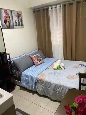 a bedroom with a bed and a window at Pierrecondotel in Manila