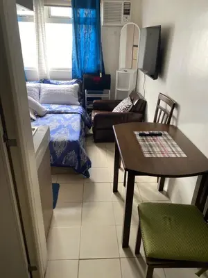 a small living room with a table and a couch at Pierrecondotel in Manila