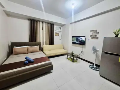 a large living room with a couch and a television at A&G Condotel at 101 Newport Across NAIA T3 in Manila