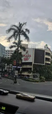 a city street with a palm tree and a building at A&G Condotel at 101 Newport Across NAIA T3 in Manila
