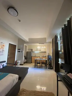 a room with a bed and a table and a kitchen at A&G Condotel at 101 Newport Across NAIA T3 in Manila
