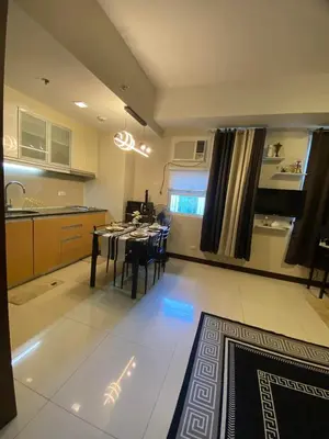 a kitchen and dining room with a table and chairs at A&G Condotel at 101 Newport Across NAIA T3 in Manila