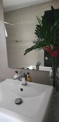 a bathroom with a white sink and a mirror at Le Palis Suite in Bukal