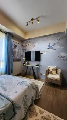 a bedroom with a bed and a flat screen tv at Le Palis Suite in Bukal