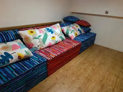 a couch with colorful pillows sitting in a room at Happy Stays C - 300mbps - 65