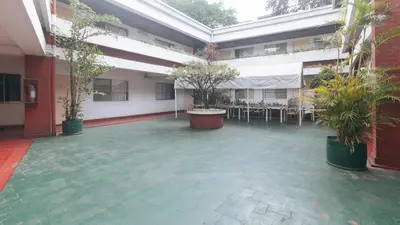 a courtyard with tables and potted plants in a building at RedDoorz at Broadway Court Apartelle II Quezon City in Manila