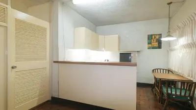 a kitchen with a counter and a table with chairs at RedDoorz at Broadway Court Apartelle II Quezon City in Manila