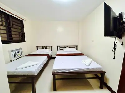 a room with two beds and a flat screen tv at OYO 1045 Rayjan Apartelle in Manila