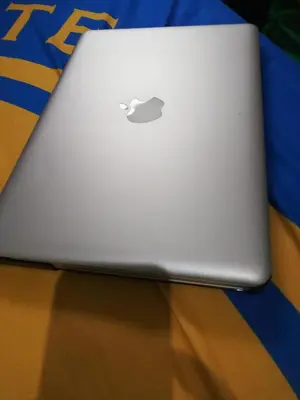 an apple laptop computer sitting on top of a table at Nicecondotel in Manila
