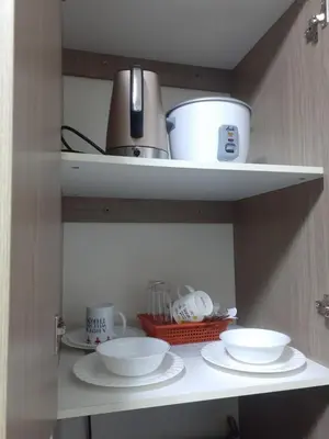 a shelf with two bowls and cups on it at Nicecondotel in Manila