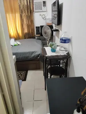 a small room with a small table and a bed at Nicecondotel in Manila