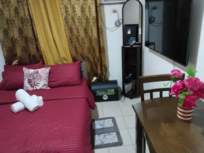 a living room with a red couch and a table at Nicecondotel in Manila