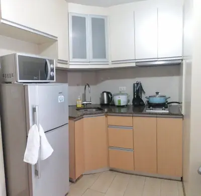 a kitchen with white cabinets and a refrigerator at RG condotel Near Naia Terminal 3 in Manila