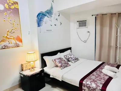 a bedroom with a bed and a table with a lamp at Dreamy Sunset Bay in Manila