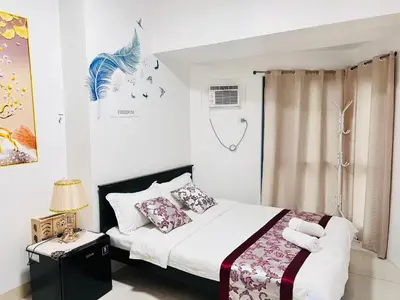 a bedroom with a bed with white sheets and pillows at Dreamy Sunset Bay in Manila