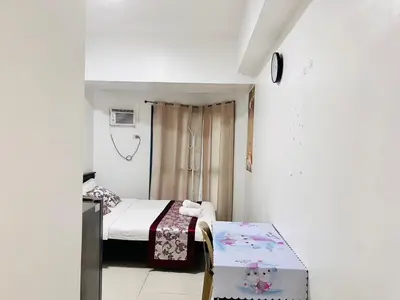 a small room with two beds and a table at Dreamy Sunset Bay in Manila