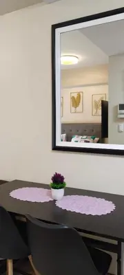 a dining room table with a mirror and a plant on it at RAMCONDOTEL in Manila
