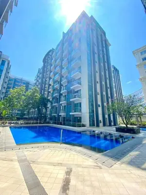 a large building with a blue pool in front of it at RAMCONDOTEL in Manila