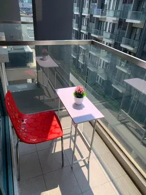 a red chair and a table on a balcony at RAMCONDOTEL in Manila