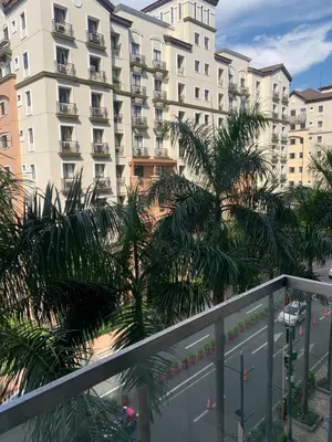 a balcony with palm trees and a large building at RAMCONDOTEL in Manila