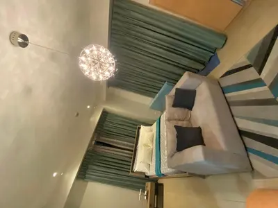 a living room with a bed and a chandelier at RAMCONDOTEL in Manila