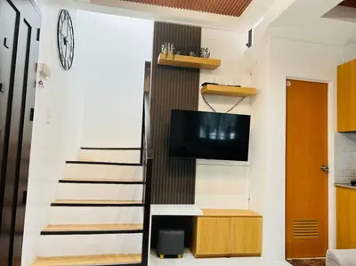 a living room with a staircase and a tv at Modern Home and Stylish Design in Ibaba