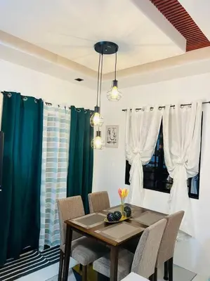 a dining room table and chairs with blue curtains at Modern Home and Stylish Design in Ibaba