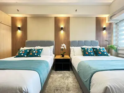 two beds in a bedroom with blue and white at Manila Bay Retreat at Soleil Suite in Manila