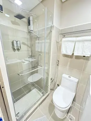 a bathroom with a toilet and a glass shower at Manila Bay Retreat at Soleil Suite in Manila