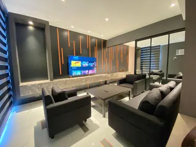 a living room with couches and a flat screen tv at Malate Bayview Mansion 17A/B in Manila