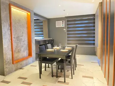 a dining room with a black table and chairs at Malate Bayview Mansion 17A/B in Manila