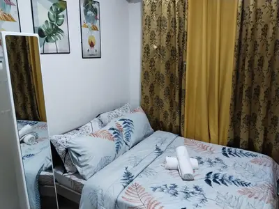 a small bedroom with a bed with white pillows at Pierrecondotel in Manila