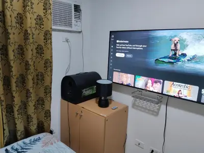 a room with a tv and a computer on a dresser at Pierrecondotel in Manila