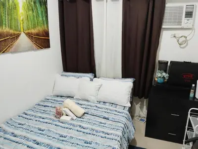 a bedroom with a bed with blue and white sheets at Pierrecondotel in Manila