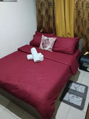 a red bed with two white pillows on it at Pierrecondotel in Manila